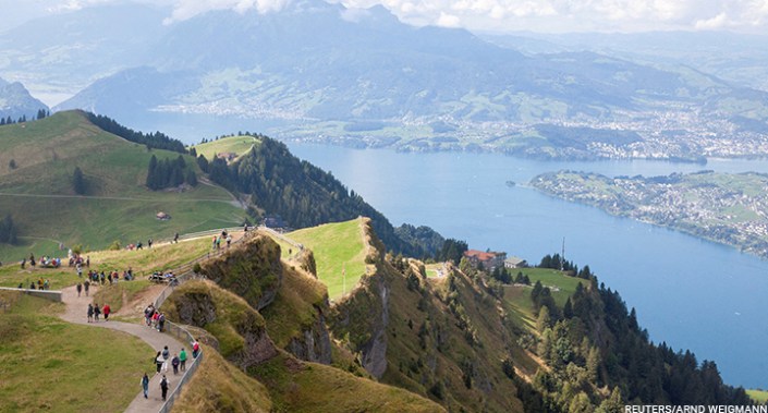 Tourists walk with Lake Lucerne seen in the background, near the peak of Mount Rigi, Switzerland 4 September 2022.