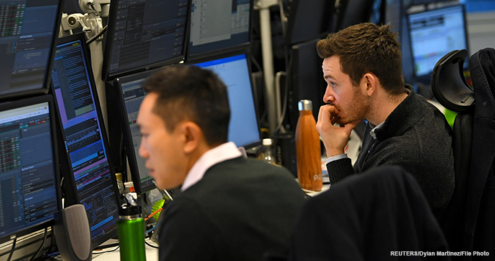 Dealers work at their desks whilst screens show market data following a vote on Prime Minister Theresa May's Brexit 'plan B' at CMC Markets in London, 30 January 2019.