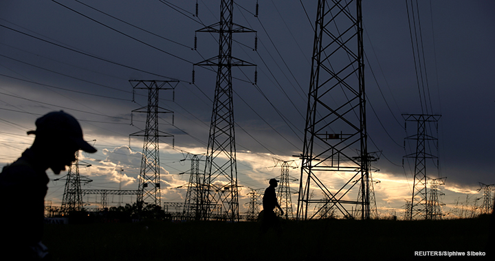 Men walk past electricity pylons as they return from work in Orlando, Soweto township, South Africa, on 18 March 2019.