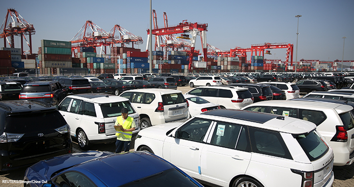 A worker inspects imported cars at a port in Qingdao, Shandong province, China.