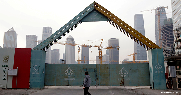 A man walks outside the construction sites in Beijing's central business area, China.