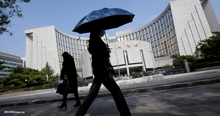 People walk past the headquarters of the PBOC, the central bank, in Beijing.