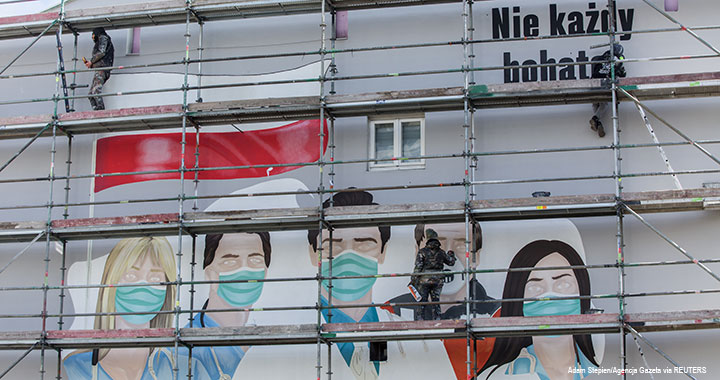 Artists paint a mural in Warsaw, Poland, 30 March 2020.