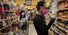 Instacart employee Eric Cohn wears a respirator mask and gloves while searching for an item for a delivery order at a supermarket in Tucson, Arizona, in the US in April.