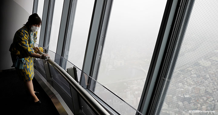 A staff member wearing a protective mask cleans a handrail with alcohol at an observation deck of Tokyo landmark "Tokyo Skytree", which reopened after a 3-month closure due to the COVID-19 outbreak, 1 June 2020.