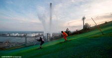 People ski down the artificial ski slope on the outdoor structure CopenHill in Copenhagen.