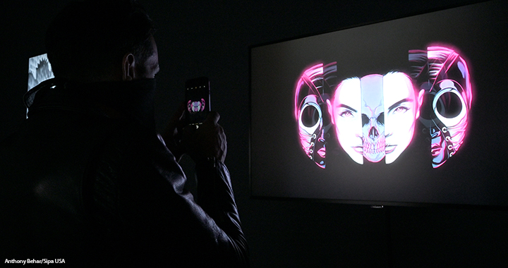 A man stands in front of a screen displaying a NFT, or nonfungible token, at the Superchief Gallery in New York City, 10 April 2021.