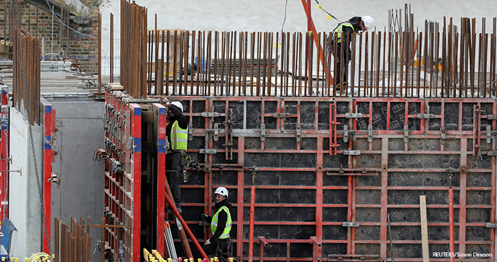 Construction workers are seen working at a site in London.