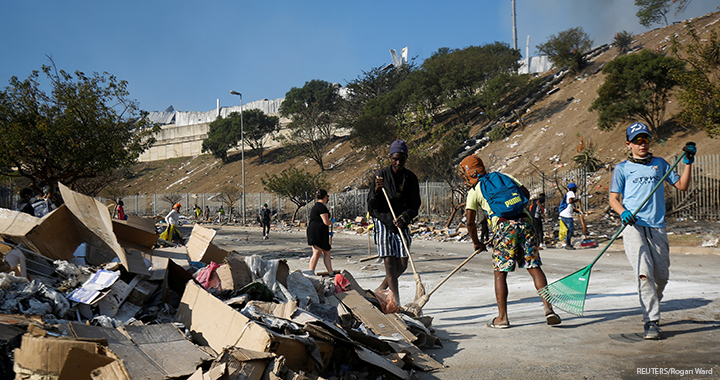 Volunteers clean up the streets after days of looting in Durban, South Africa, 15 July 2021.