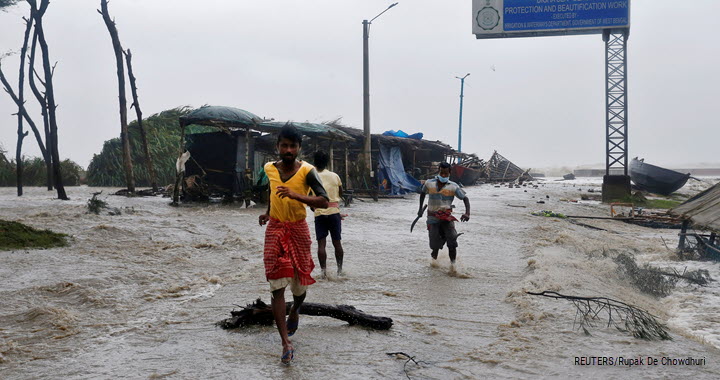 People run on a waterlogged road due to rising sea level ahead of Cyclone Yaas at Digha in Purba Medinipur district in the eastern state of West Bengal, India, 26 May 2021.