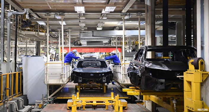 Employees of SAIC Motor work on the car production line at the automaker's Lingang base, which has resumed production amid the COVID-19 outbreak in Shanghai, China, 23 April 2022.