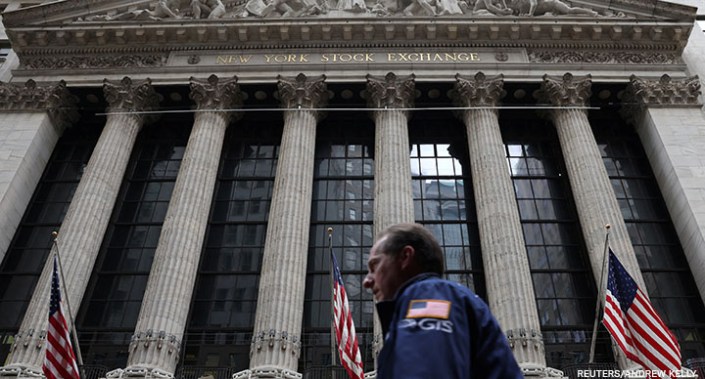 A trader walks by the New York Stock Exchange (NYSE) in Manhattan, New York City, US, 19 May 2022.