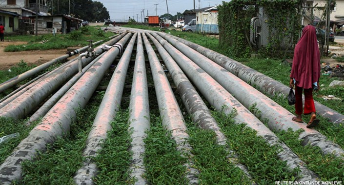 A girl walks on a gas pipeline running through Okrika community near Nigeria's oil hub city of Port Harcourt, 4 December 2012.