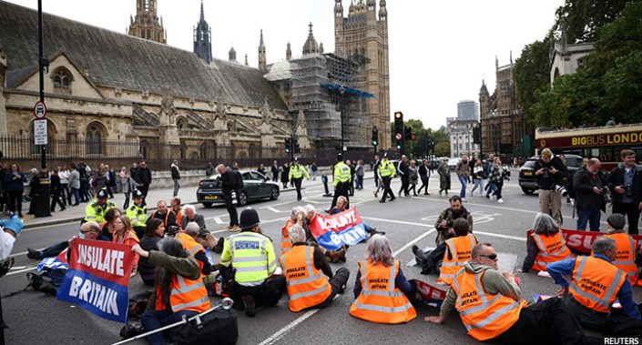 Insulate Britain activists block the road outside the Houses of Parliament during a protest in London on Wednesday.