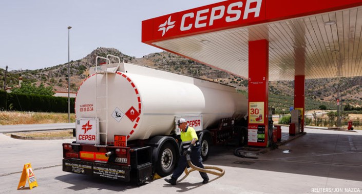 A worker prepares to deliver fuel at a Cepsa petrol station, during the first heatwave of the year in Cuevas del Becerro, Spain, 13 June 2022.