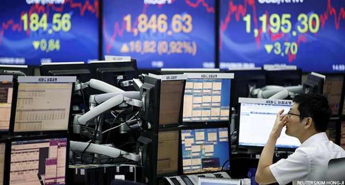 A currency dealer works in front of electronic boards at a dealing room of a bank in Seoul, South Korea, 25 August 2015.