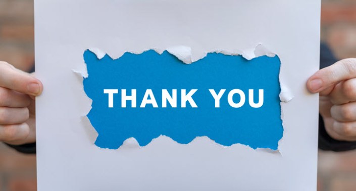 Person holding "thank you" sign.